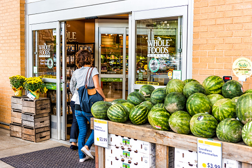 Fairfax: People, women, female entering Whole Foods Market grocery store building in city in Virginia with autumn displays and watermelons