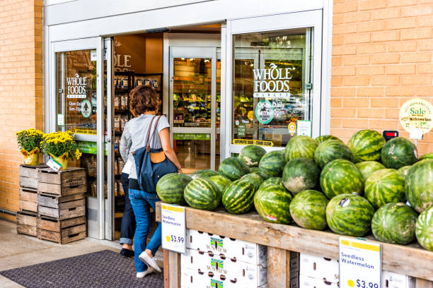 People, women, female entering Whole Foods Market grocery store building in city in Virginia with autumn displays and watermelons Fairfax: People, women, female entering Whole Foods Market grocery store building in city in Virginia with autumn displays and watermelons fairfax virginia photos stock pictures, royalty-free photos & images