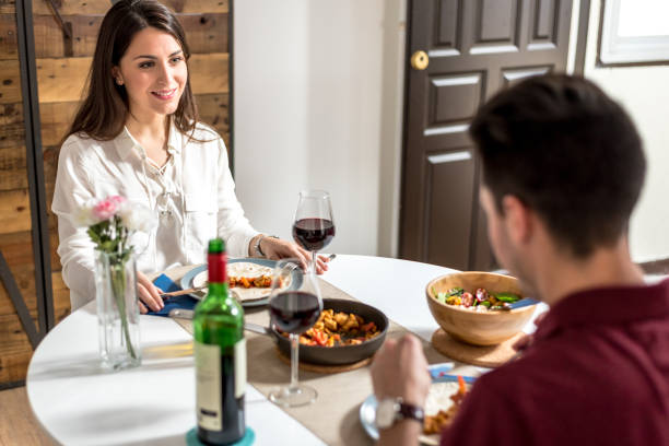 istock Happy young couple eating and drinking wine at home 855629140