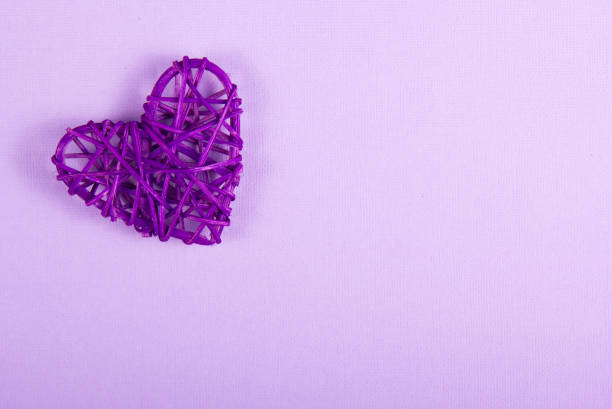 Wicker Valentine on a purple background. St. Valentine's Day. Copy space