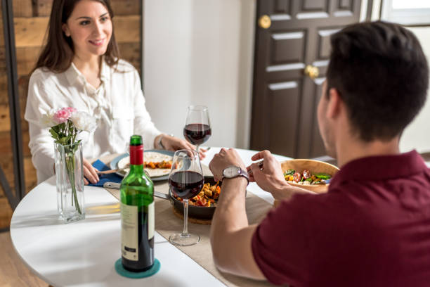 istock Happy young couple eating and drinking wine at home 855629284