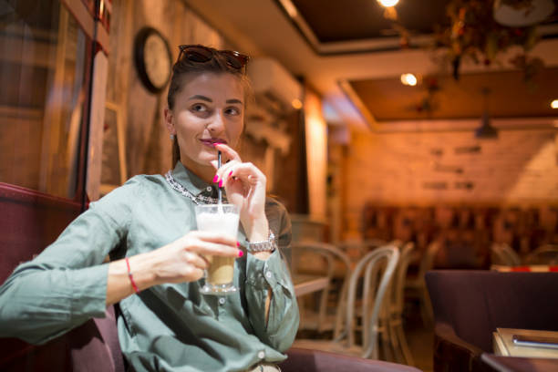 istock Smiling woman drinks coffee in coffee shop 855641810