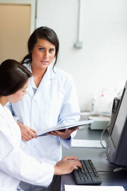 istock Portrait of cute scientists looking at a report 855644924