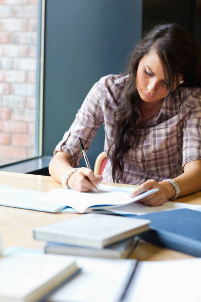 istock Portrait of a beautiful student writing an essay 855651222