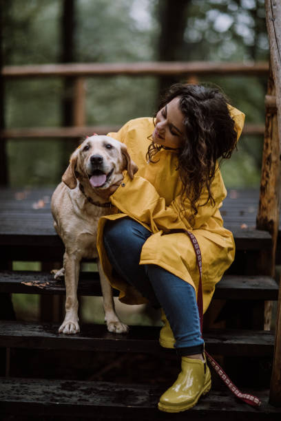 istock Young woman enjoying rainy day with her dog 855656846