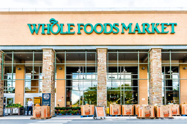 green whole foods market znak sklepu spożywczego na zewnątrz budynku w mieście w wirginii z ludźmi spaceru i jesienią wyświetla dynie na halloween - 4729 zdjęcia i obrazy z banku zdjęć