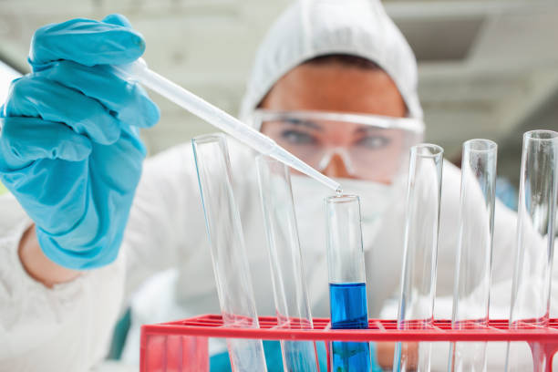 istock Close up of a protected scientist dropping liquid in a test tube 855667584