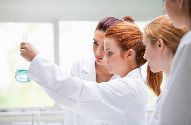 istock Cute chemistry students holding a flask 855670312