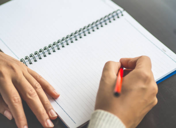 istock Selective focus woman hand writing with red pencil on working table. Business and education concept. 855686702
