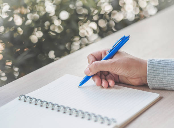 istock Woman hand writing with blue pen on working table. Business and education concept. 855686728