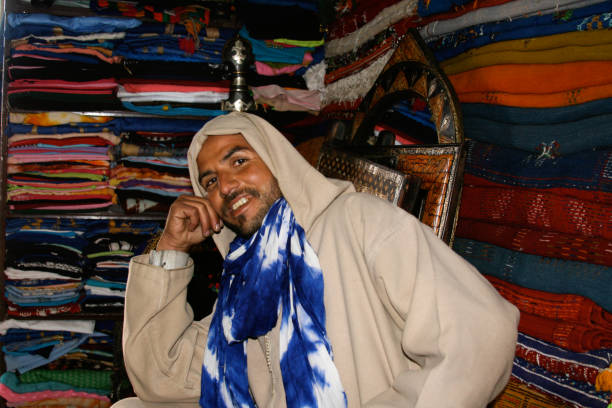 Morocco, Marrakesh, man walking by white wall in market place. Y apr 6 2019