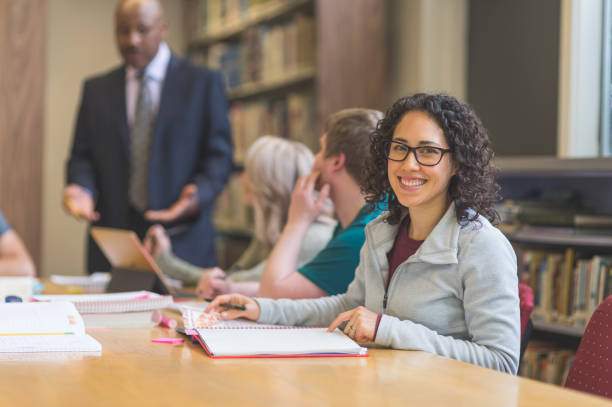 istock College students study together in the university library. An African American professor is helping them. 855690500