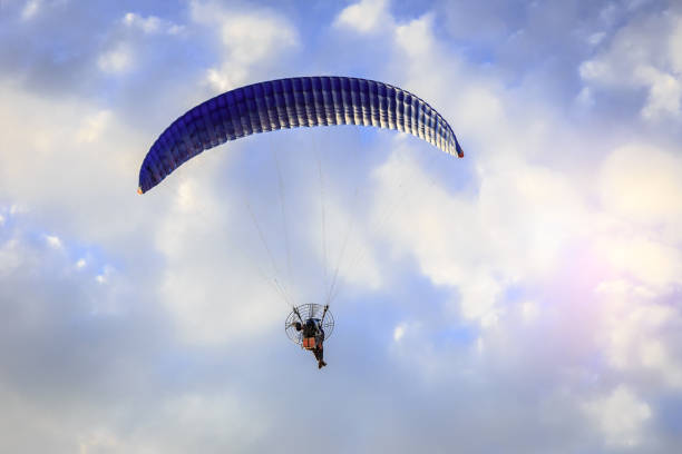 istock Paragliding flying in the blue sunny sky with clouds 855694230