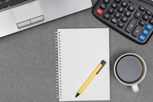 istock Laptop computer or notebook, calculator and cup of coffee on working table with copy space top view. 855698640