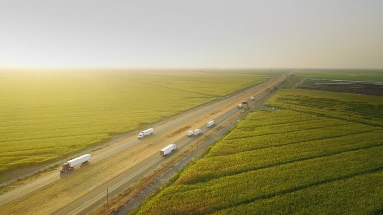 Sunset drone shot of Interstate 5 cutting across farmland in the California Central Valley.