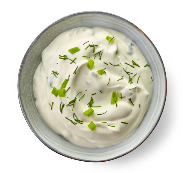 Bowl of sour cream sauce Bowl of sour cream dip sauce with herbs isolated on white background, top view dipping sauce stock pictures, royalty-free photos & images