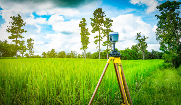 gps surveying instrument install on tripod in green rice field, thailand - azimuth imagens e fotografias de stock