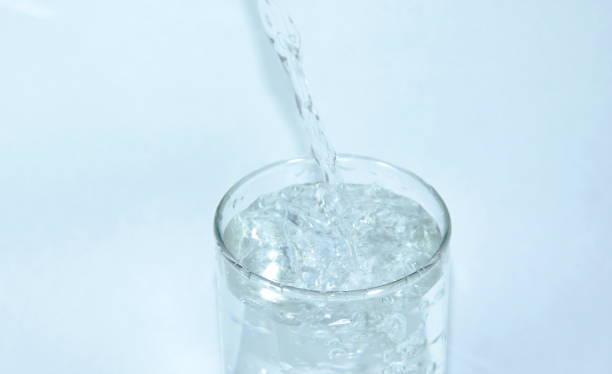 istock water pouring in glass on white background 855729500