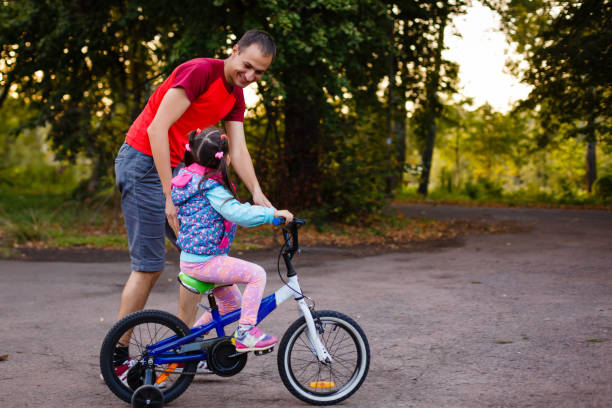 istock Father teaching his daughter to ride a bike 855748920