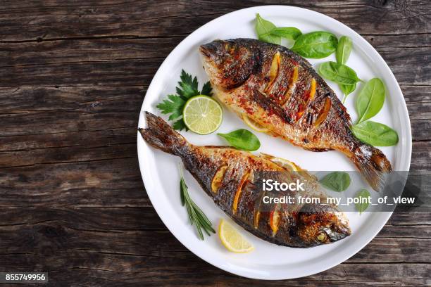 Roasted Sea Bream Fish With Lemon Slices Stock Photo - Download Image Now - Fish, Grilled, Seafood
