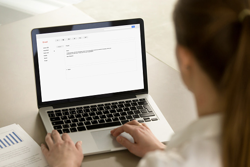 Empresaria escribiendo corporativo de correo electrónico utilizando la computadora portátil en la oficina de photo