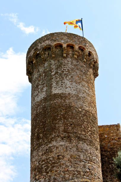 A Senyera estelada, the unofficial flag typically flown by Catalan independence supporters, waving on the tower of Tossa de Mar Fortress, Catalonia, Spain