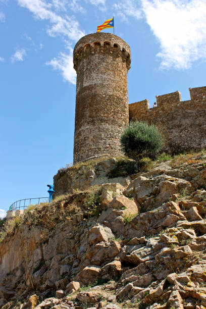 A Senyera estelada, the unofficial flag typically flown by Catalan independence supporters, waving on the tower of Tossa de Mar Fortress, Catalonia, Spain