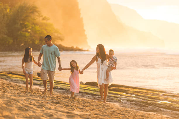 istock Hawaiian family walk on sandy beach at sunset 855758646