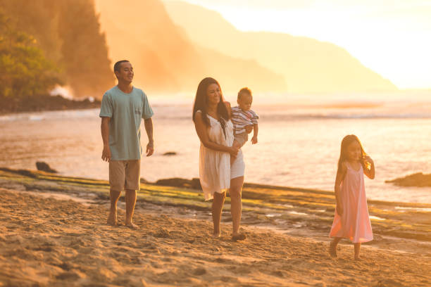istock Hawaiian family walk on sandy beach at sunset 855758652