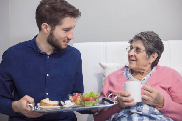 helping to the elderly - senior adult nursing home eating home interior imagens e fotografias de stock