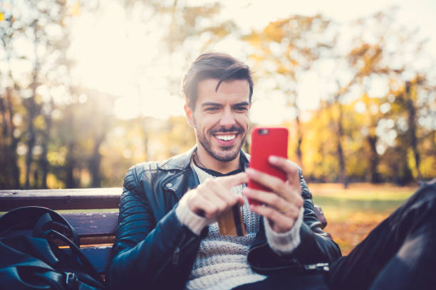 istock Young man in the park shopping online 855760874