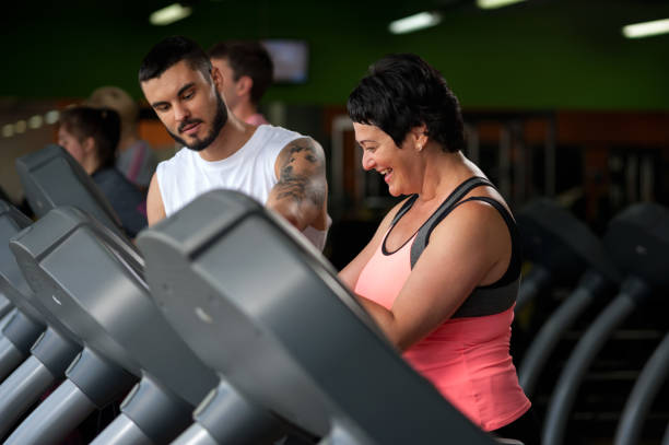 istock Fitness coach assisting his client on treadmill 855768258