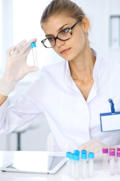 female scientific researcher in laboratory studying substances or blood sample. medicine and science concept - close up medical test exam people imagens e fotografias de stock