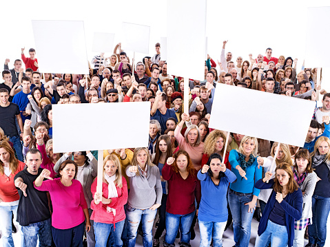 High angle view of large group of people. Some of them are holding white banners and showing thumbs down. Isolated on white. Copy space.