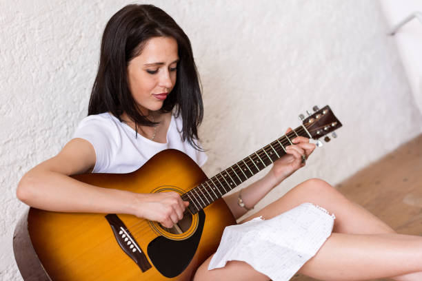 istock Woman playing Acoustic Guitar 855775026