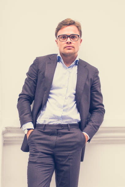imprenditore maschio alla moda in posa per la macchina fotografica - pocket suit glasses jacket foto e immagini stock