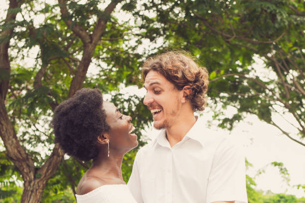 cheerful couple embracing and laughing in park - wedding african descent american culture bride imagens e fotografias de stock