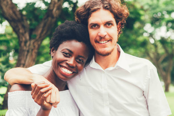 istock Pretty young couple hugging in public park 855775474