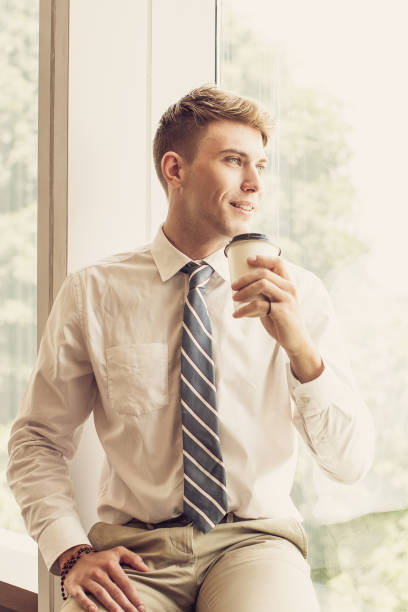 istock Smiling Business Man Drinking on Window Sill 855775750