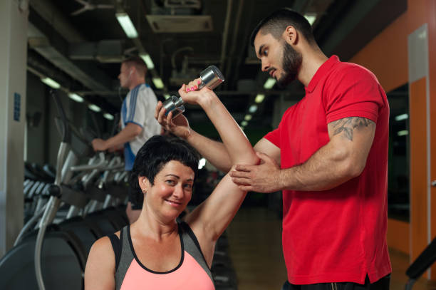 istock Brunette middle aged woman working out with coach 855778664