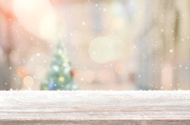 istock Wood table top on blur with bokeh christmas tree background with snowfall - can be used for display or montage your products. 855778706