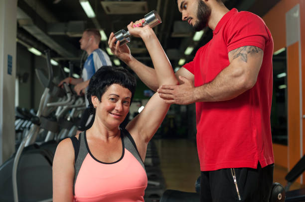 istock Brunette middle aged woman working out with coach 855778734