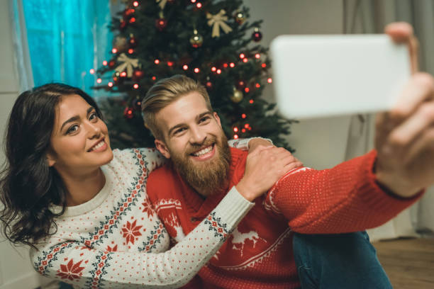 istock couple taking selfie with christmas tree 855788760