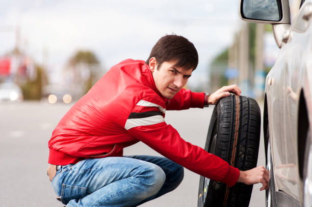 istock Young man changing tire on road after breakdown 855788856