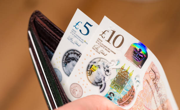 New British ten pound and five pound polymer notes in a wallet Edinburgh, UK - Closeup of a person opening a leather wallet to pay with newly issued British polymer banknotes, featuring holographic security features, and a watermark of Queen Elizabeth II's image. elizabeth ii photos stock pictures, royalty-free photos & images