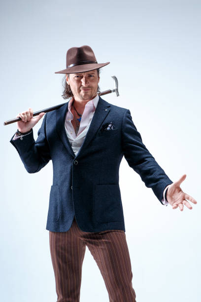 istock The mature man in a suit and hat holding cane 855792736