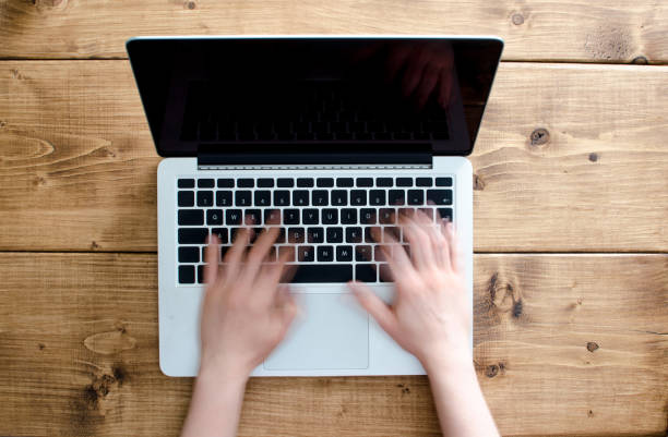istock Hands writing on a laptop with black screen background with copy space 855795920
