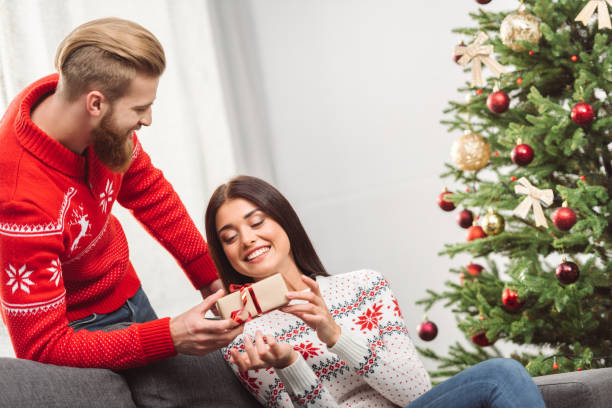 istock man presenting christmas gift to girlfriend 855795980