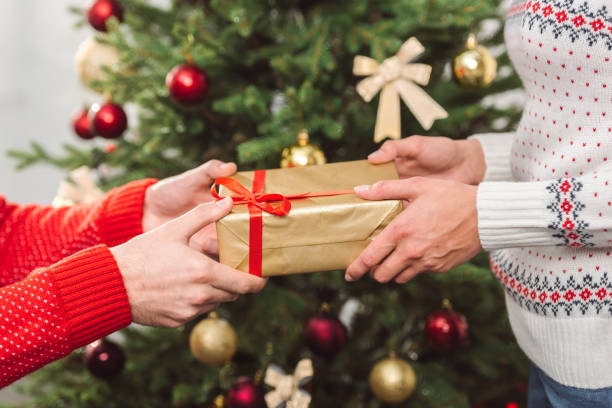 istock man presenting christmas gift to girlfriend 855796250