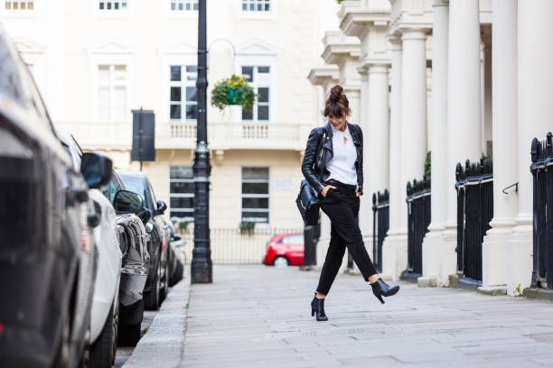Happy woman dancing in the city street Fashion portrait of beautiful woman dancing in the city street in London. Autumn season. london fashion stock pictures, royalty-free photos & images